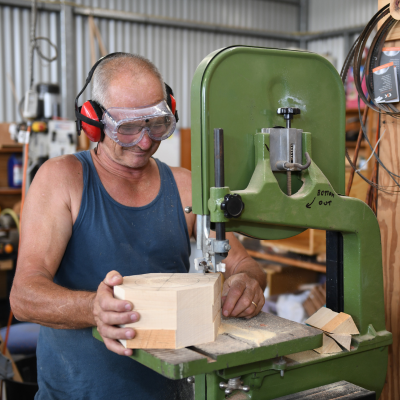 Man using a machine to cut wood