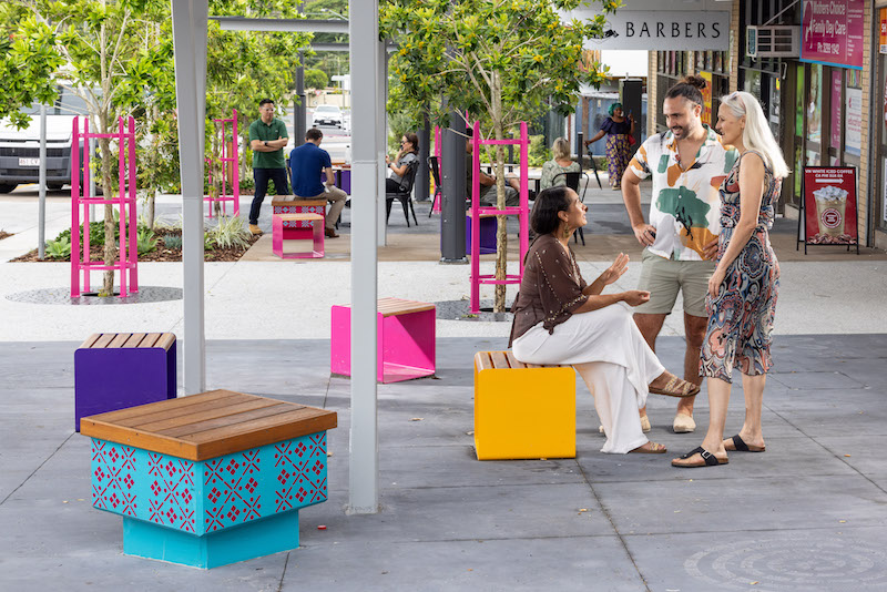 Business precinct with outdoor seating and group of three people