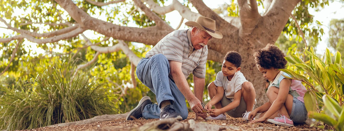 Man and children playing under a tree