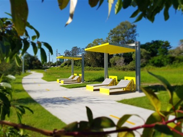 Slacks Creek track activation, sunlounges along the path with yellow shelter