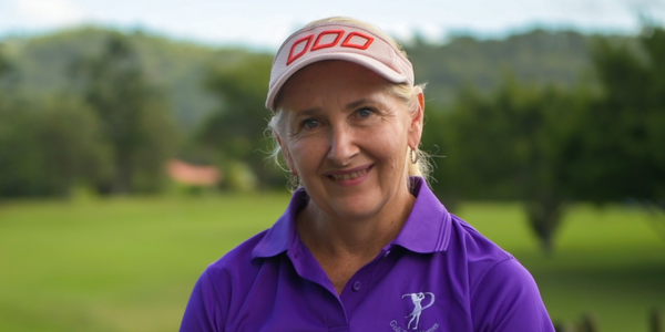 Woman in purple shirt holds golf club