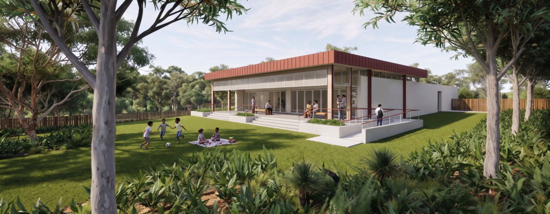 Architectural rendering of a modern single-storey community building surrounded by landscaped gardens and mature trees. A large lawn extends in front of the building, with people using the outdoor space, including children playing and a group seated on a picnic rug. The building features wide steps, accessible ramps with handrails, and a covered veranda with floor-to-ceiling glazing.