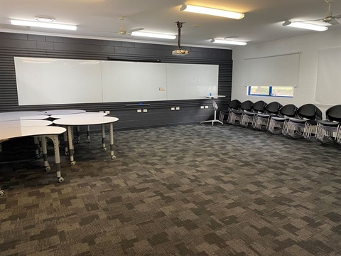An room with tables and chairs set up for learning activities