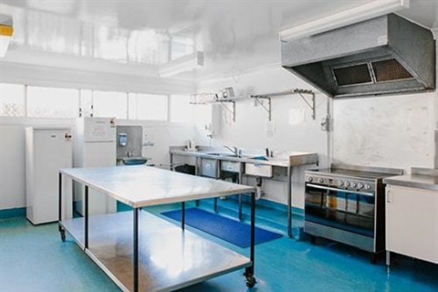 white kitchen with stainless steel appliances and blue flooring