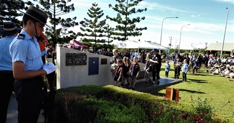 People paying their respects at the cenotaph at Logan Central