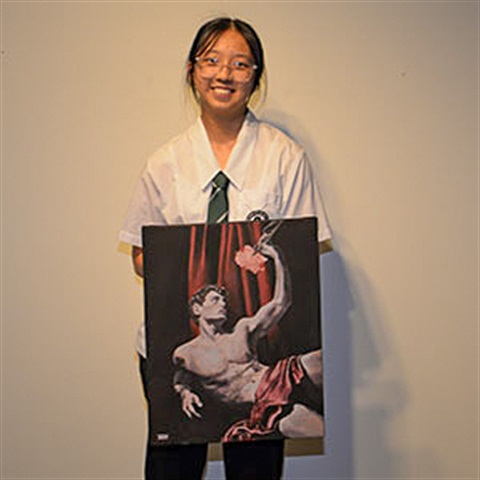 Park Ridge State High School student Xin Weng holding up a painting
