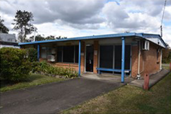 Frontage of business at Rochedale South, an older red brick facade with faded blue painted trim and an old door