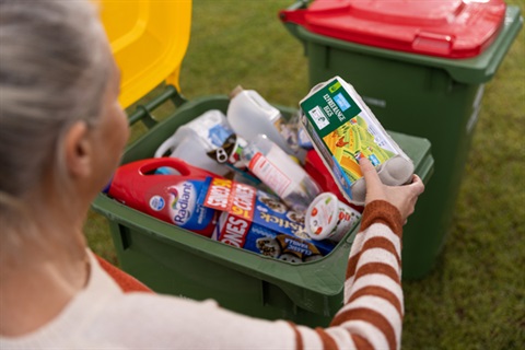 Women placing egg carton in recycling bin