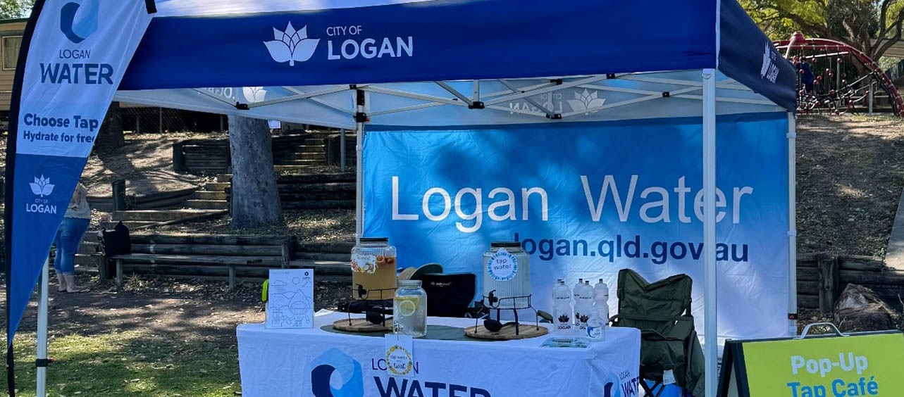 Logan water signage surrounds logan water cafe set up in outdoor area