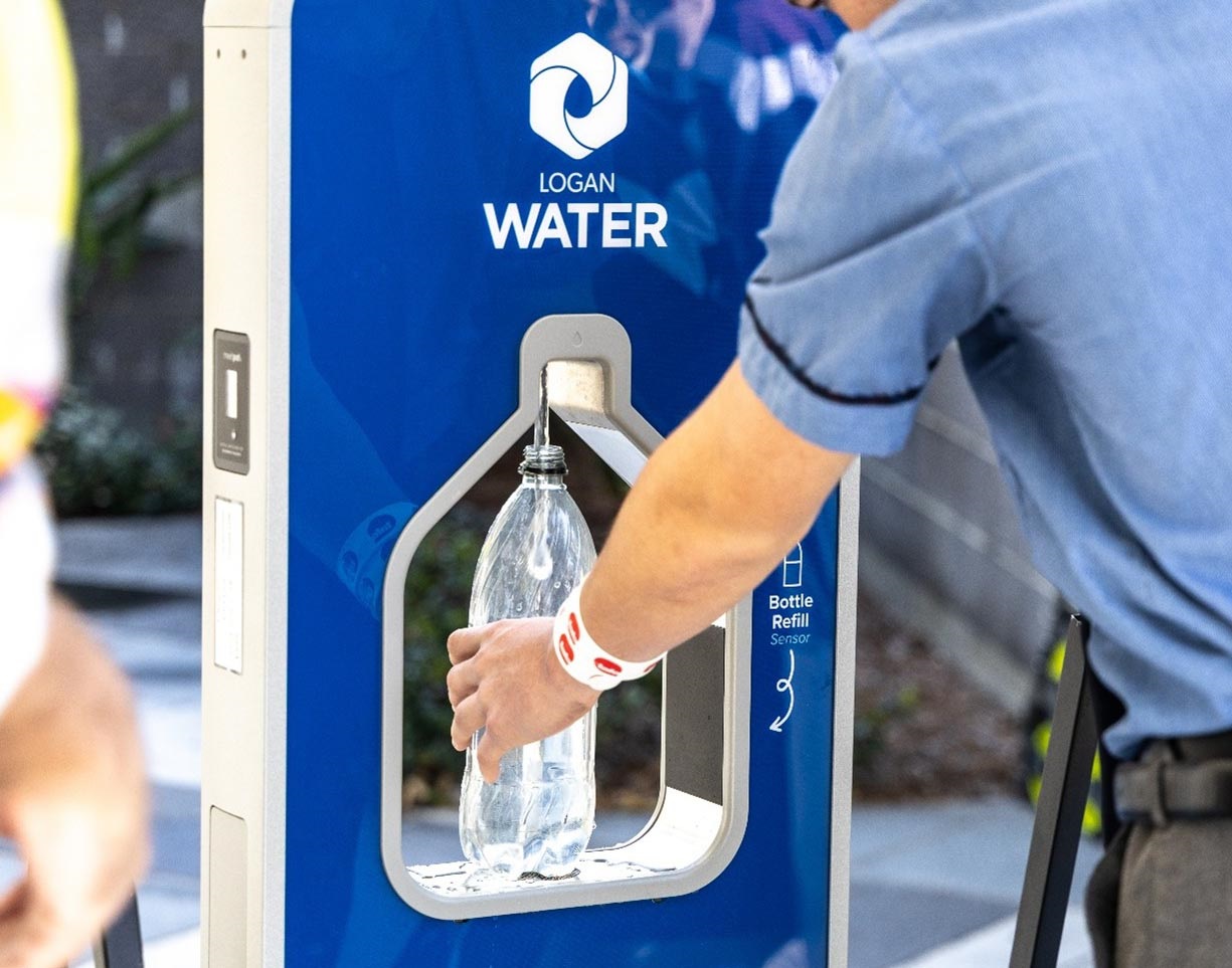 Man fills water bottle in portable water station