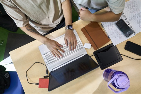 Top down view of people working on laptop
