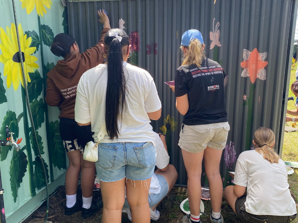 Volunteers painting a floral mural at Jimboomba Community Garden