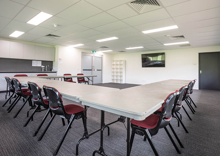Conference room with tables and chairs set up in centre of the room