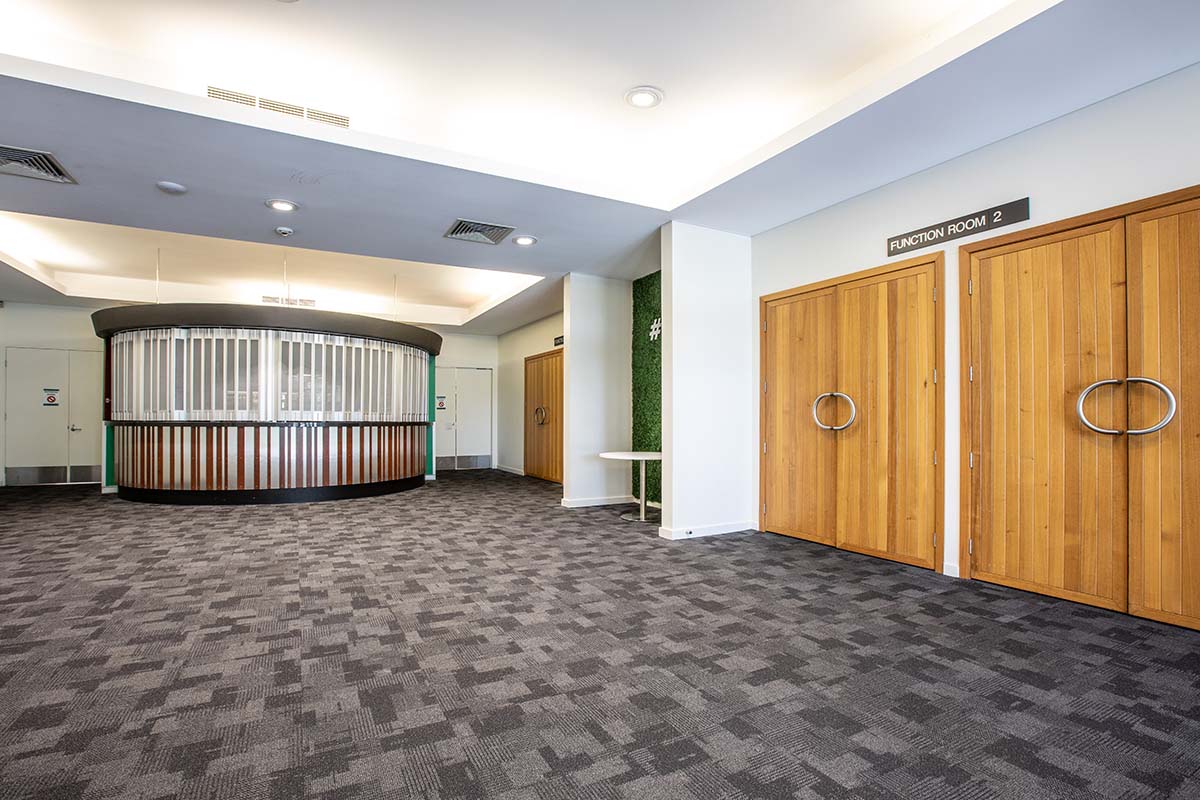 Carpeted foyer area with double wooden doors and circular bar