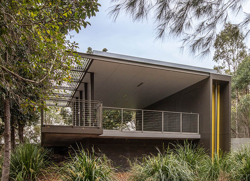 Rear view of walkway showing under cover and fenced shelter surrounded by trees