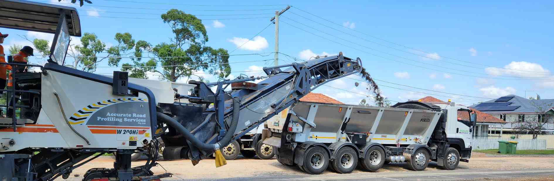 Two pieces of machinery resurfacing a road