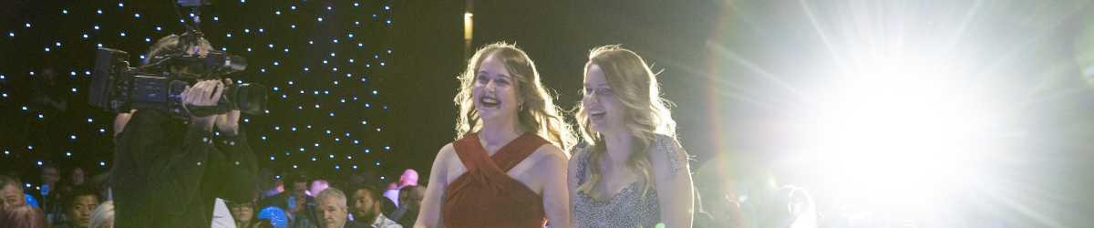 Two women smile as theyre followed by camera at Sports Awards