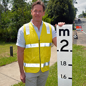 An image of Mayor Darren Power at a local flood marker that was covered by near-record flood waters last February-March.