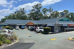 Facade of block of shops after renovation - signage is upgraded, and carpark surface has been improved.