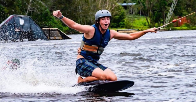 Man wakeboarding and smiling to the camera