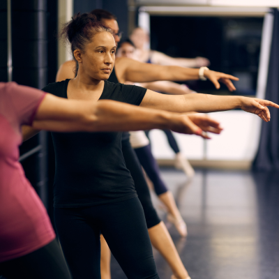 A line of women doing a pli&eacute; of the bar