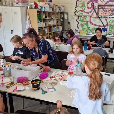A group of children sitting around a table making art of out reusable items