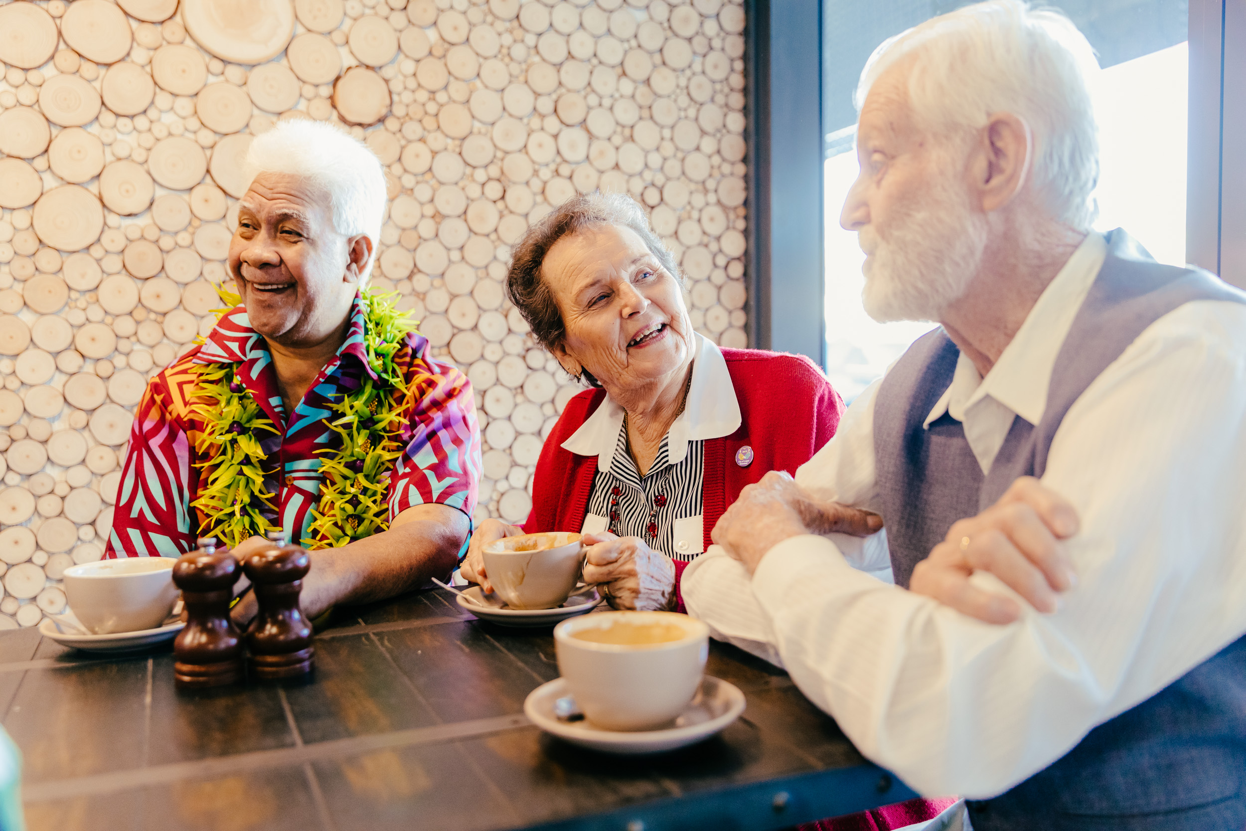 3 seniors chatting over a cup of coffee.