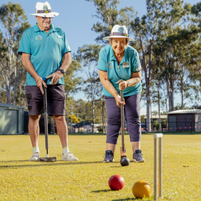 An elderly couple playing croquet