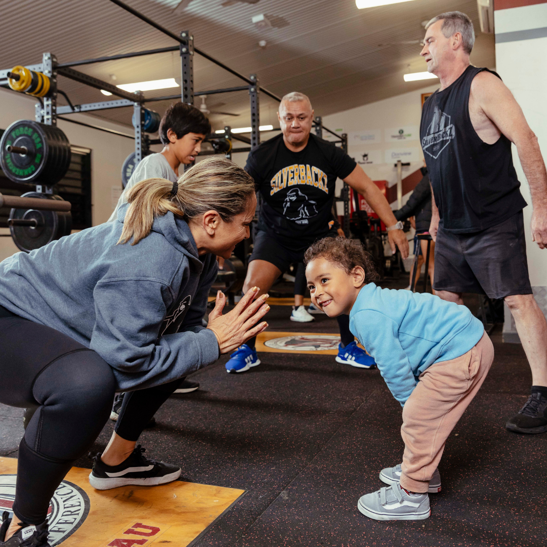 A group of people stretching in a gym.