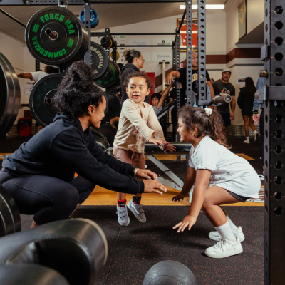 a family in the gym doing a squat