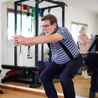Elderly man in a squat workout position