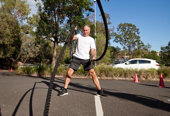 A man doing an exercise with ropes.
