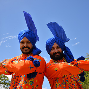 Two men in traditional Punjabi Bhangra dress pose for a photo to promote the new Active and Healthy program activities, including a Punjabi Bhangra dance class.