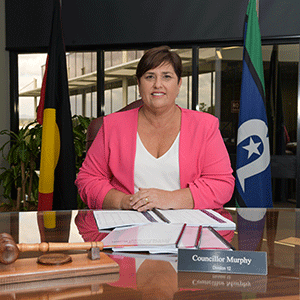 Councillor sits behind desk and looks at budget papers.