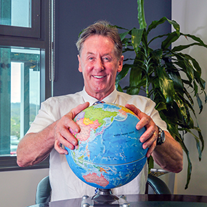 An image of City of Logan Mayor Darren Power with his hands on a globe to demonstrate he is ready to take a global view on quality-of-life issues.