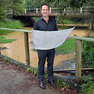 An image of Mayor Jon Raven looking at updated flood-risk mapping for Windaroo Creek at Noyer Park.