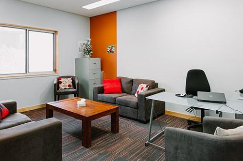 Room with couches, a coffee table, filing cabinet and computer desk