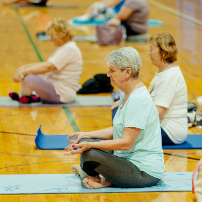 A line of women on yoga mats meditating