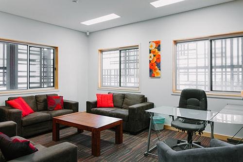 Room with couches, a coputer desk and coffee table