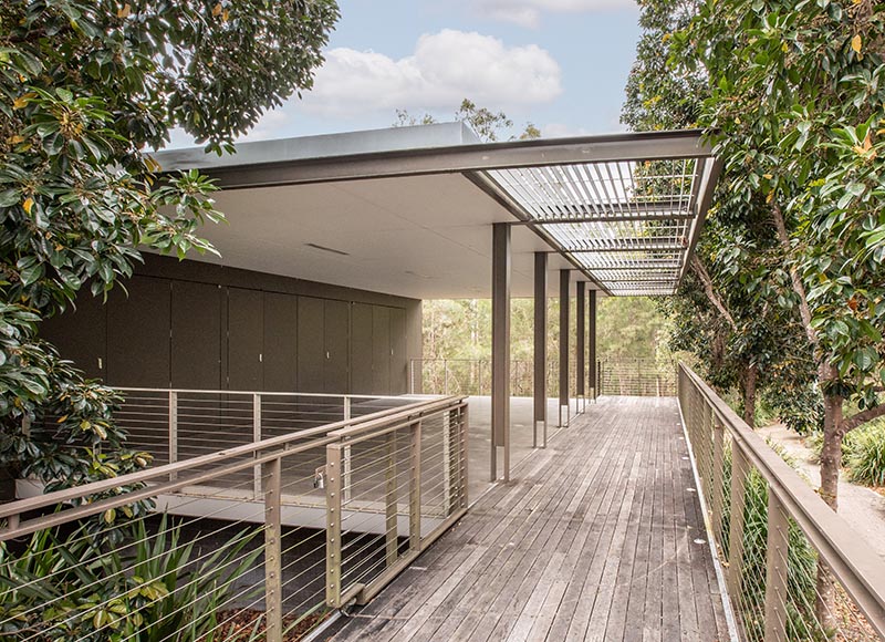 Entrance to a fenced under cover area surrounded by trees