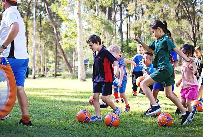 Kids playing soccer in the park.