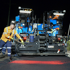 Man works on roadworks with heavy machinery