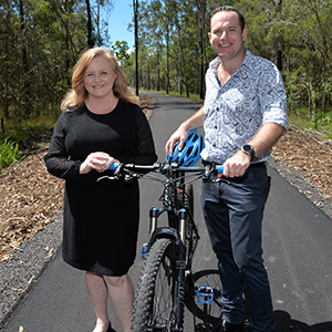An image of Acting Mayor Jon Raven, holding a bicycle, and City Lifestyle Chair and Division 4 Councillor Laurie Koranski on the new Logan Village to Yarrabilba Rail Trail.