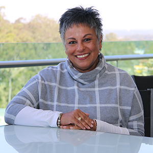 And image of Logan City Council Interim Administrator Tamara O'Shea sitting at a desk.