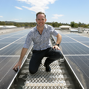 An image of Logan City Council Deputy Mayor Jon Raven inspecting the new solar system on the roof of Council headquarters in Logan Central.