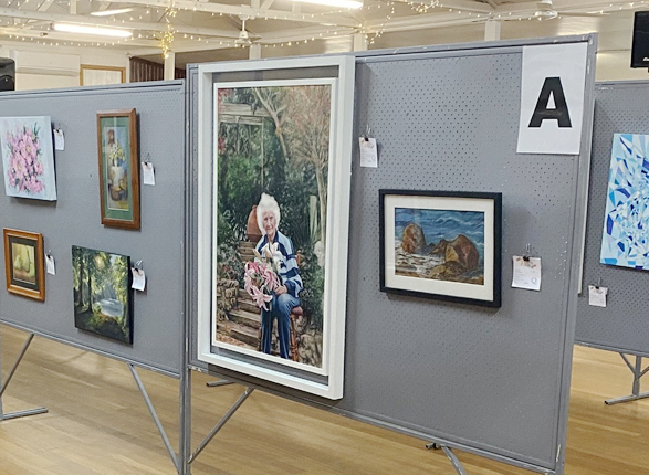 Various art pieces hanging on a display wall.