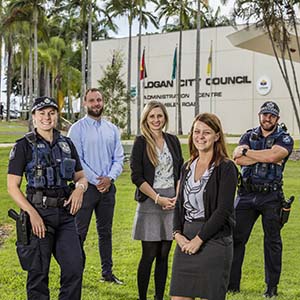 This is a photo of two police officer and three council staff standing in front of the administration building
