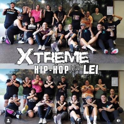 Extrmee hip hop with Lei a group of people sitting on the ground against a window smiling and crossing their arms
