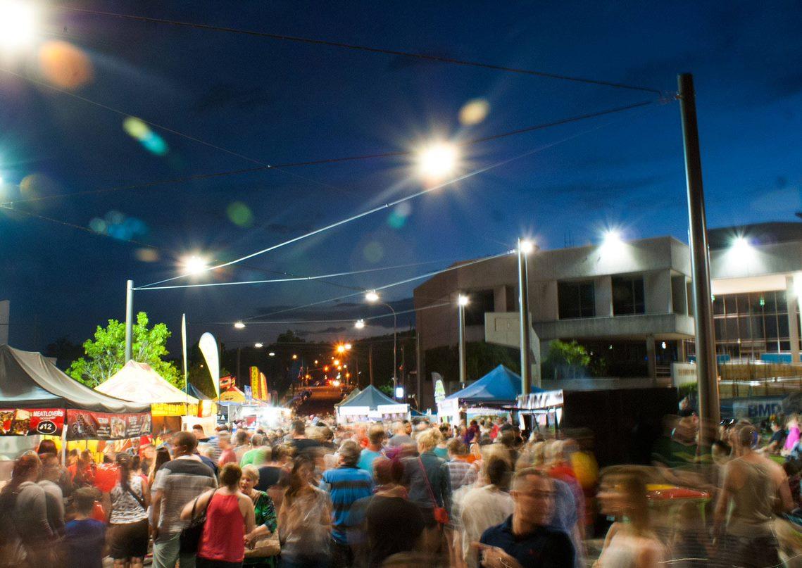 Picture of the Beenleigh night markets with people walking through the streets and market tents along the street