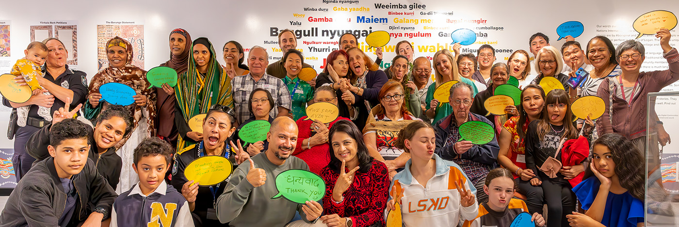 Culturally diverse group of people holding up signs with greetings in other languages